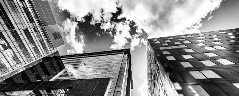 Black and white image of city buildings seen from below