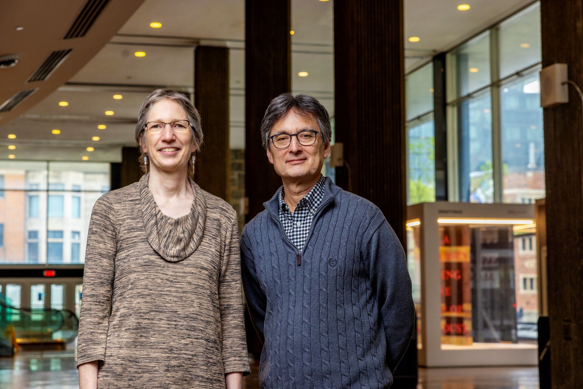 Pascale Biron and James Grant Deux scientifiques se tiennent dans l'atrium d'un bâtiment universitaire.