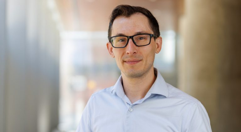 Un homme à lunettes portant une chemise bleue