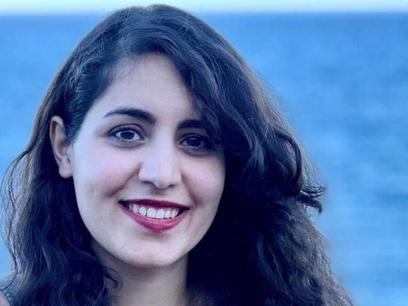 Une femme aux longs cheveux bruns souriante