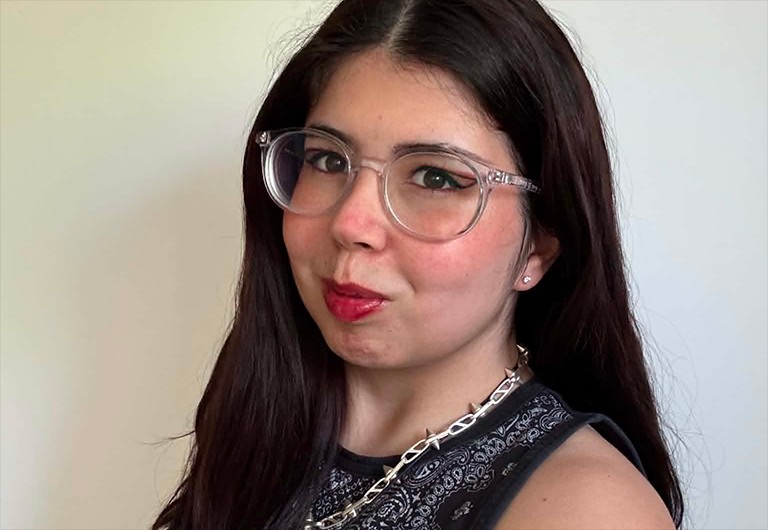 Jeune femme souriante, aux longs cheveux bruns et portant des lunettes