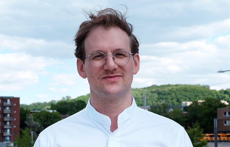 Smiling young man in spectacles and a white shirt.