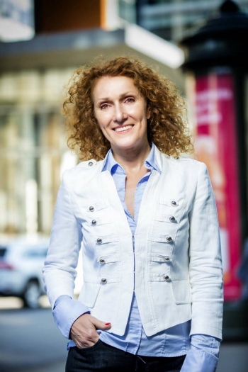 Woman with white jacket and curly hair