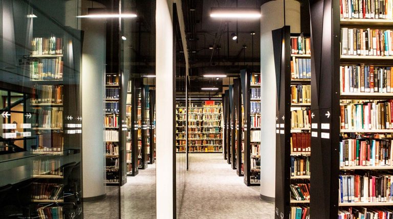 A corridor with books on bookshelves in a library.