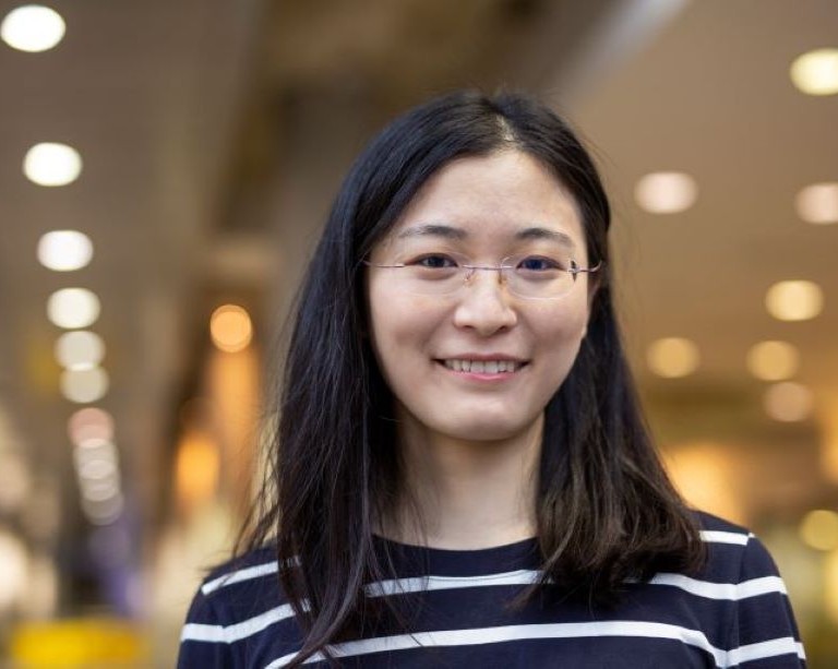 Portrait of Qi Feng, a young smiling woman with long dark hair.