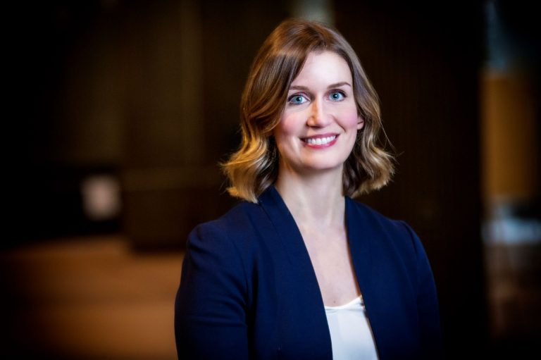 Portrait of Nicole Alberts, woman with medium-length brown hair wearing a blue jacket