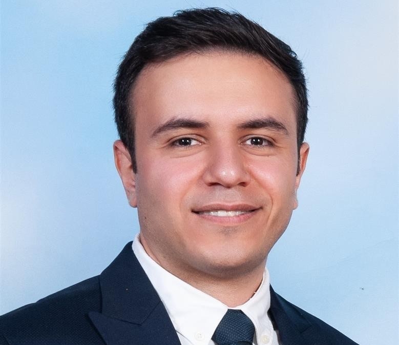 Nima Bonyadi headshot of man wearing blazer blazer, white collared shirt and black tie