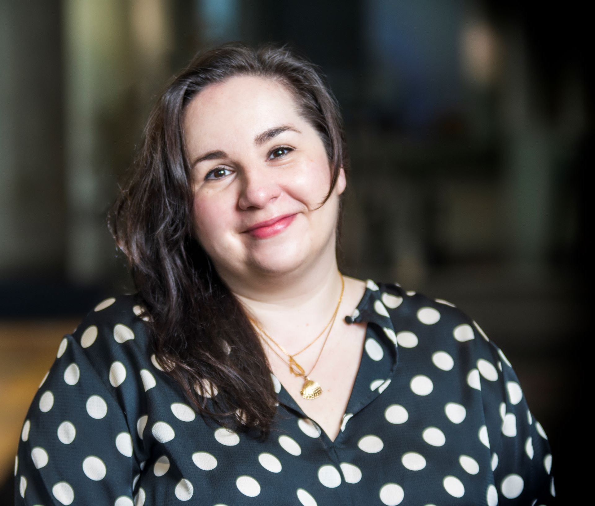 Woman with black hair in polka dot shirt