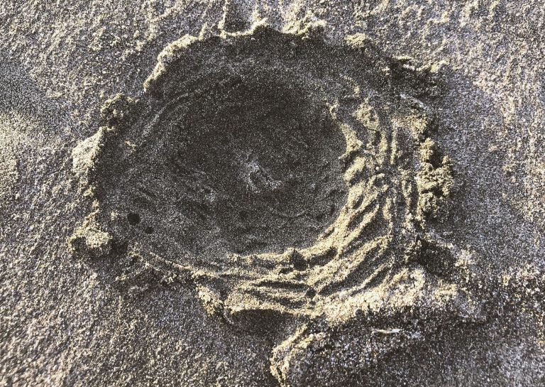 Model moon crater imprinted in sand