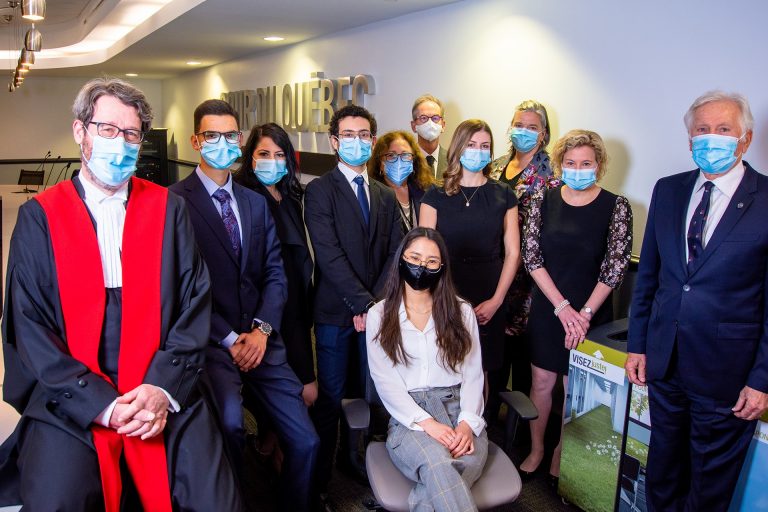 Group shot of 11 masked individuals dressed in business attire, with judge on the left.