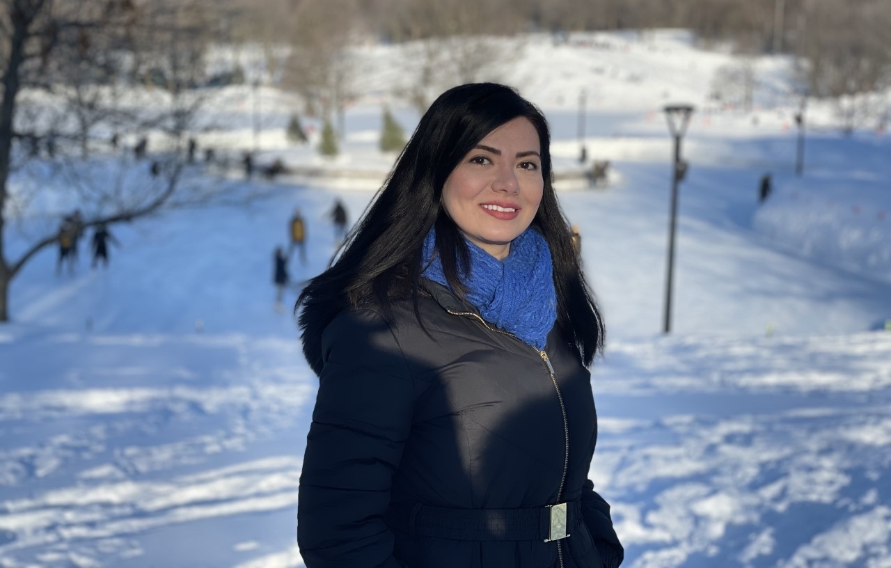 Young woman in dark coat standing outside in winter