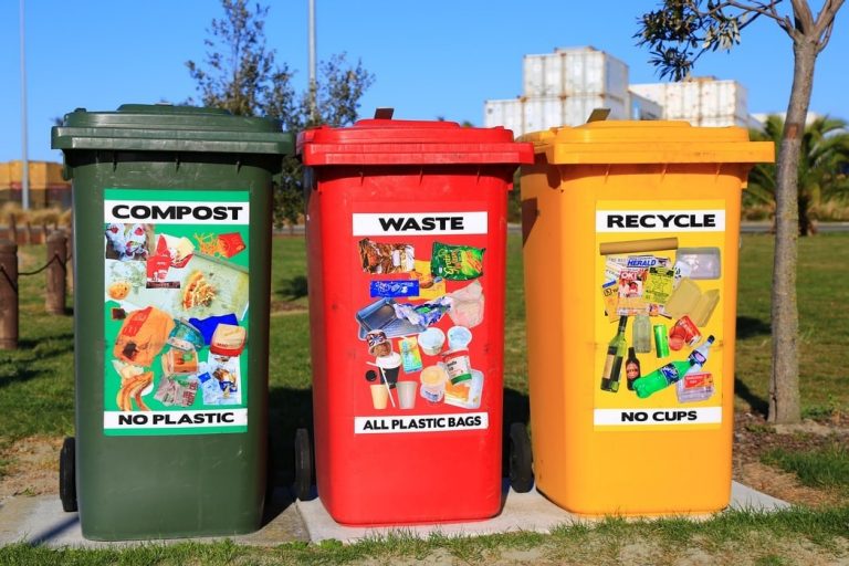 A green, a red and a yellow waste bin outside