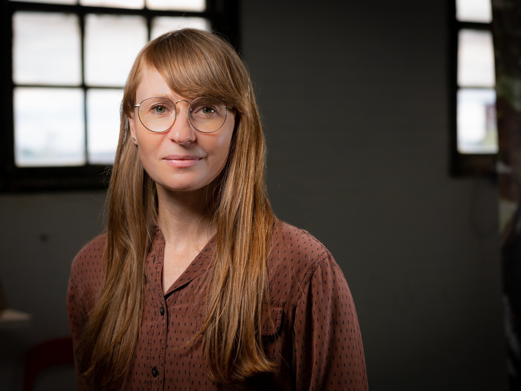 Woman with glasses and long hair smiling