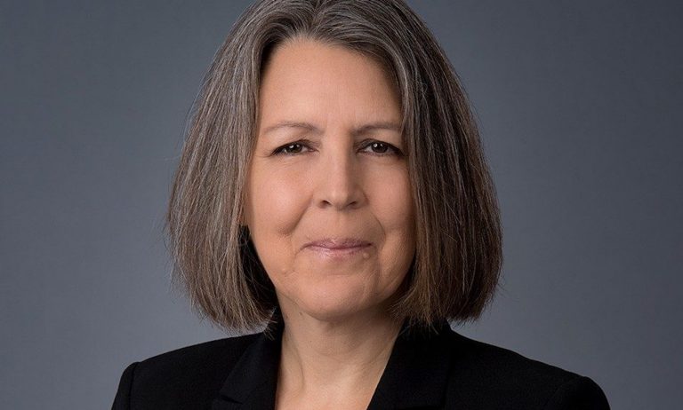 A nêhiyaw iskwêw (Plains Cree woman) with shoulder-length, dark hair, smiling eyes and a black jacket.