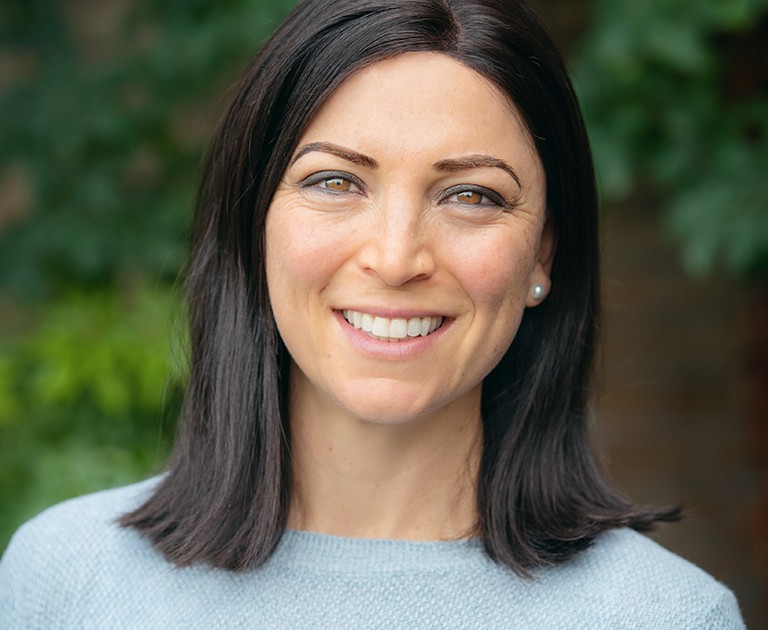 Young, smiling woman with long, dark hair.