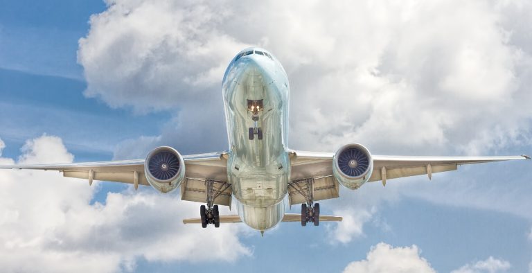 An airplane flying in front of clouds