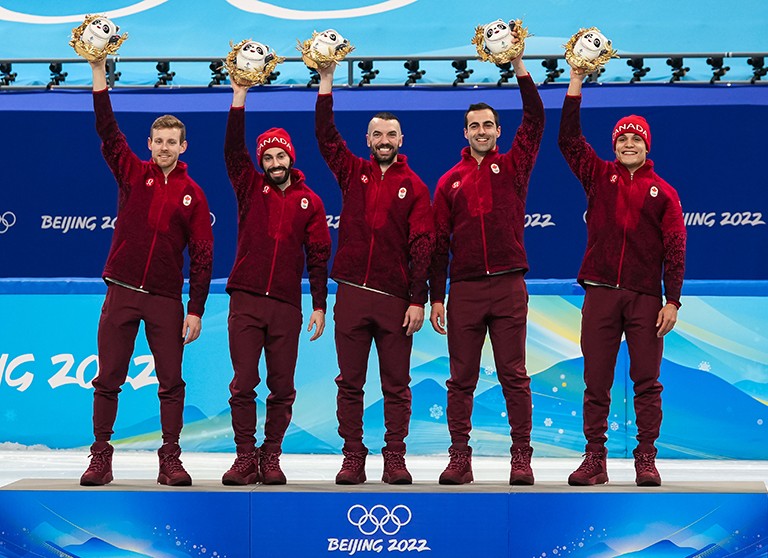 Five athletes on the podium at the Beijing 2022 Winter Olympics.