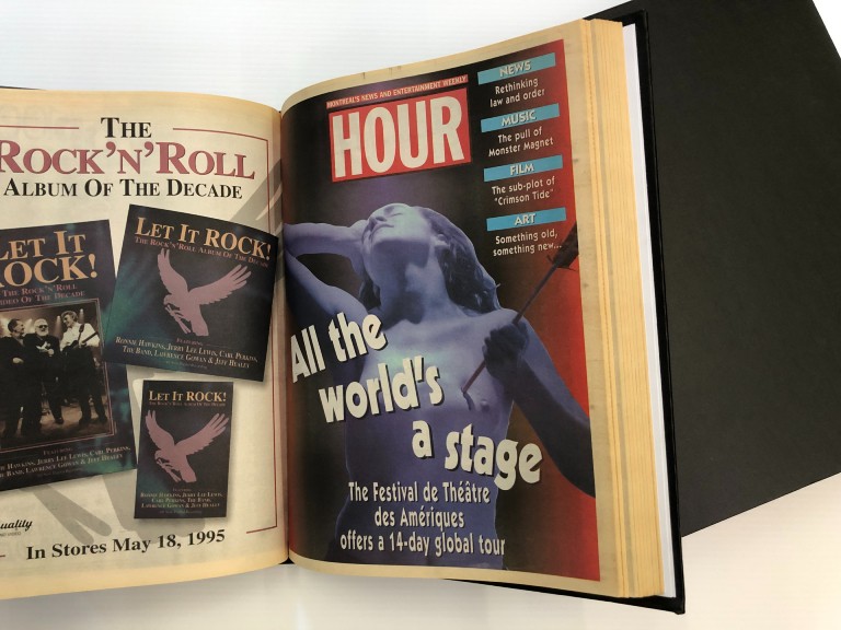 Hard-cover black book opened to a spread of a preservation of an aged news weekly cover with woman with woman with arrow in chest headline "All the world's a stage"