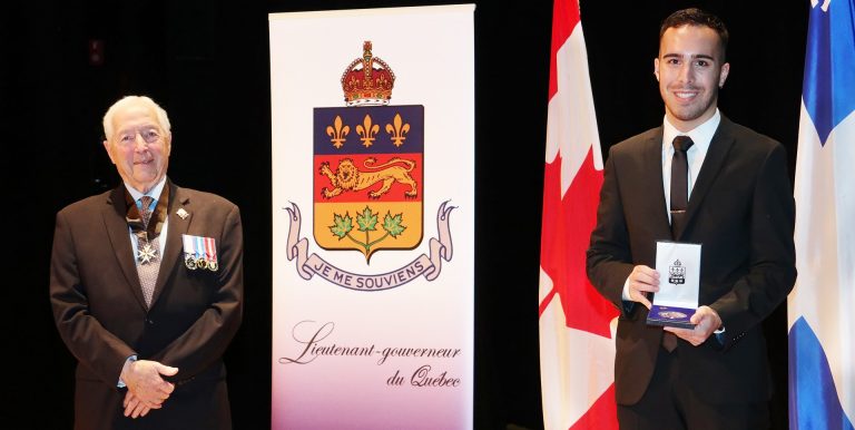 An older gentleman and a young man at an awards ceremony.