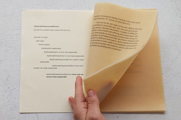 A hand leafing through pages of a book