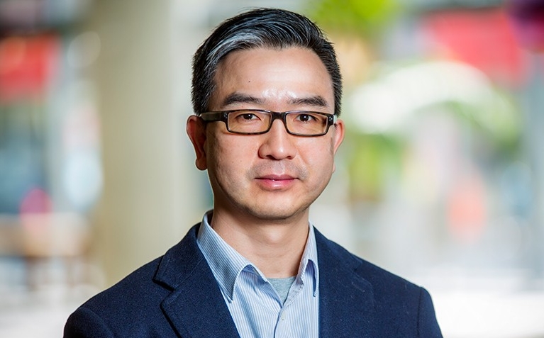 Liangzhu (Leon) Wang, associate professor in the Department of Building, Civil and Environmental Engineering, A slightly smiling Asian man with dark-rimmed glasses, short hair, a blue shirt and blue blazer.
