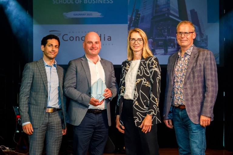 Concordia's Faisal Shennib, Paul Blouin and Yvan Soucy with Annie Guertin, director of Coordination and Social Innovation in Energy Transitions, Ministry of Energy and Natural Resources. | Photo: BOMA Quebec Image showing three men standing with a woman on stage smiling. One of the men is holding a prize statue.