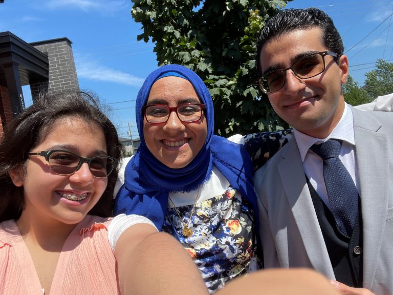 A selfie of three siblings wearing glasses smiling
