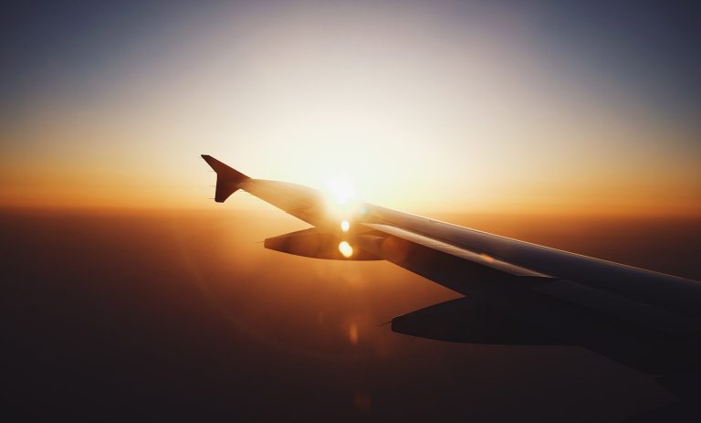 A sunset seen over the wing of a flying aeroplane.