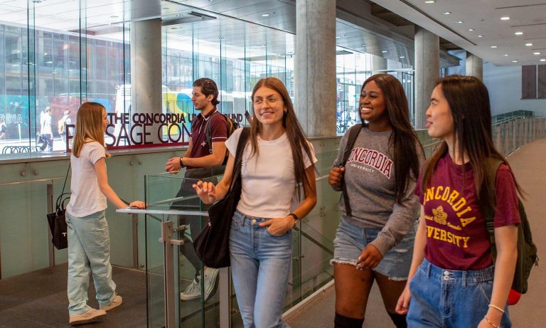 A building interior with a group of students walking and talking together.