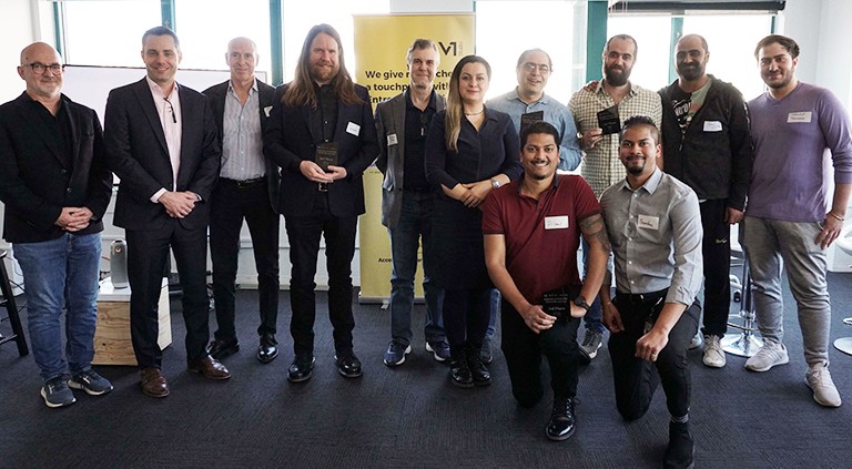 Back row: Xavier-Henri Hervé, Ari Kiriazidis, Randall Kelley, Jonathan Roy, Michael Wood, Mahsa Alimi, Meysam Taghinasab, Mohammad Mortezazadeh, Saeed Rayegan and Sepehrdad Tahmasebi. Bottom row: Dilan Jaunky, Brandon Jaunky. | Photo by Alice Vervaeke A group of people standing in an interior in two rows and smiling for the camera.