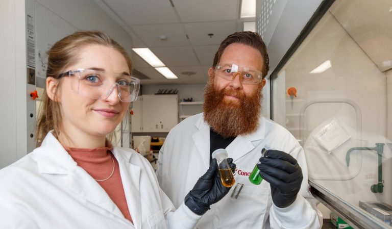 Adryanne Clermont-Paquette and Rafik Naccache wear lab coats and hold fluorescent solutions