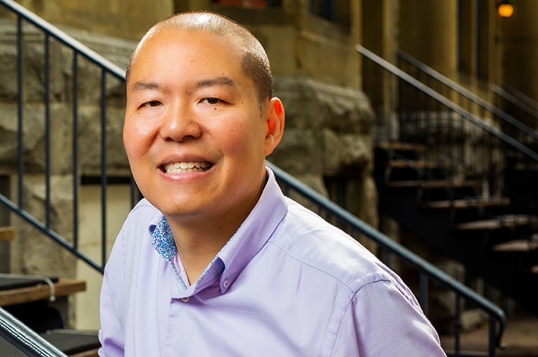 Bruno Lee: “The expected outcomes of the project will benefit Canada by cutting a large portion of emissions in existing building stock.” Smiling man with close-cropped, dark hair and wearing a mauve dress shirt.