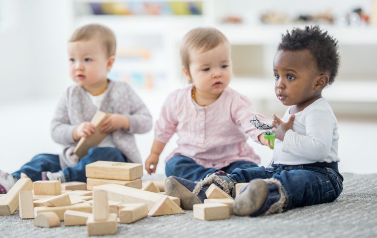 Three babies playing with blocks