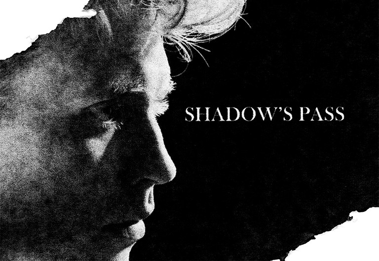 Black and white image of a face in profile, with the words, "Shadow's Pass" on a black background.