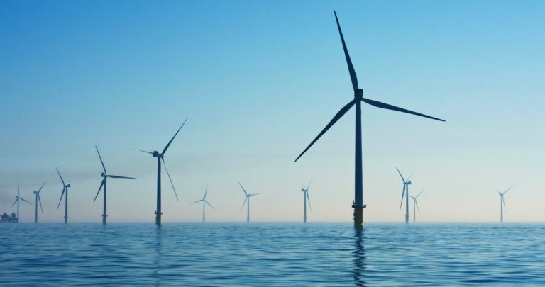 Turbines of an offshore wind farm stand out of the ocean