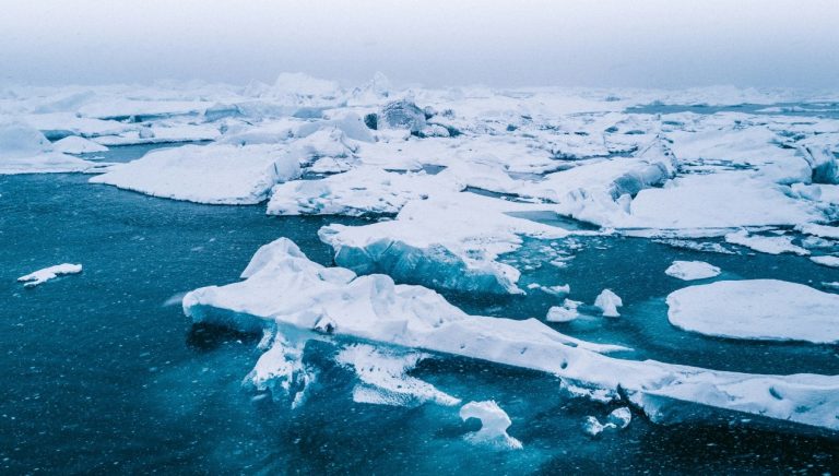 Ice bergs float in a deep blue ocean