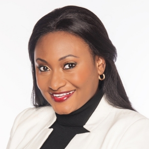 Smiling woman with long, dark hair, wearing red lipstick, a black top and a white blazer