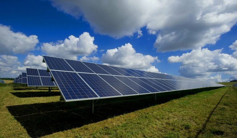 Solar panels in a grass filed, on a sunny day with clouds