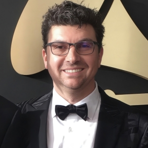 Smiling man with short dark hair, wearing a tuxedo
