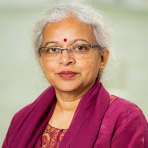 Smiling woman with long, silver hair and glasses