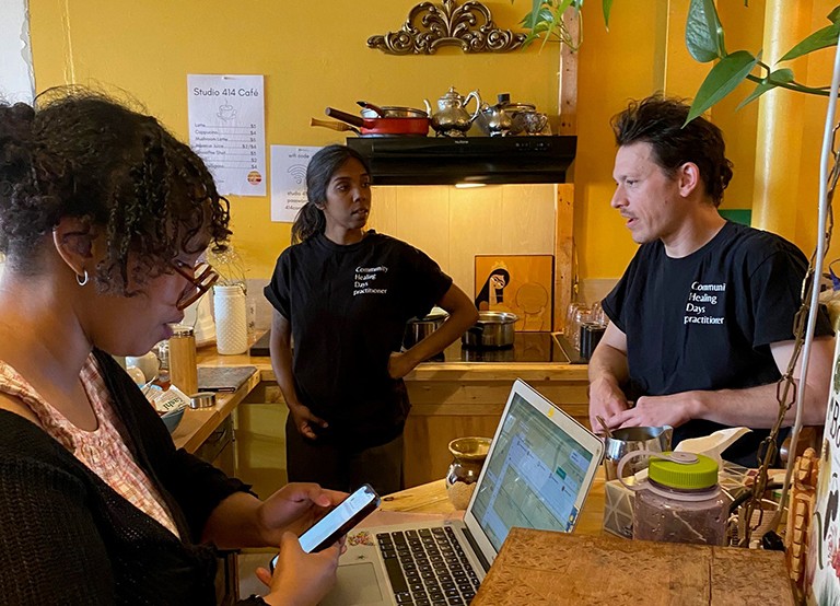 SHIFT intern Hamda Elmi’s (left) empathy and dedication have earned the trust of clients and made her a cherished member of the organization. Two women and a man in a community kitchen