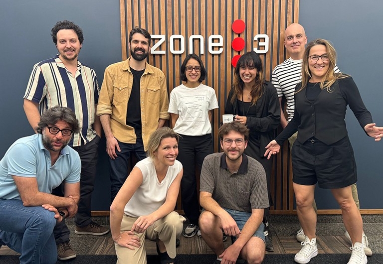 A group of people, some kneeling, some standing, smiling for the camera