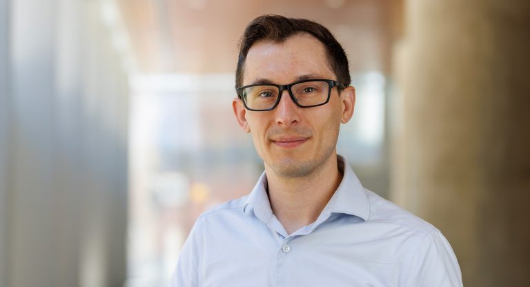 A man with glasses in a blue shirt