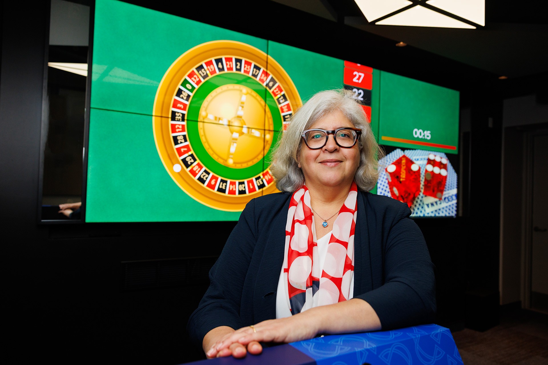 Sylvia Kairouz in front of a simulated casino screen