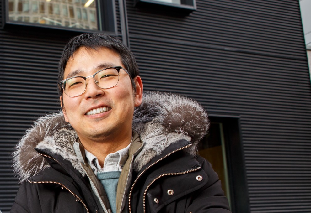 A man wearing a cold weather jacket and glasses smiling