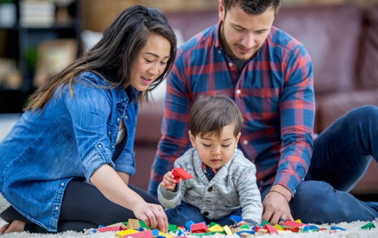 An Asian mother and European father play with their child