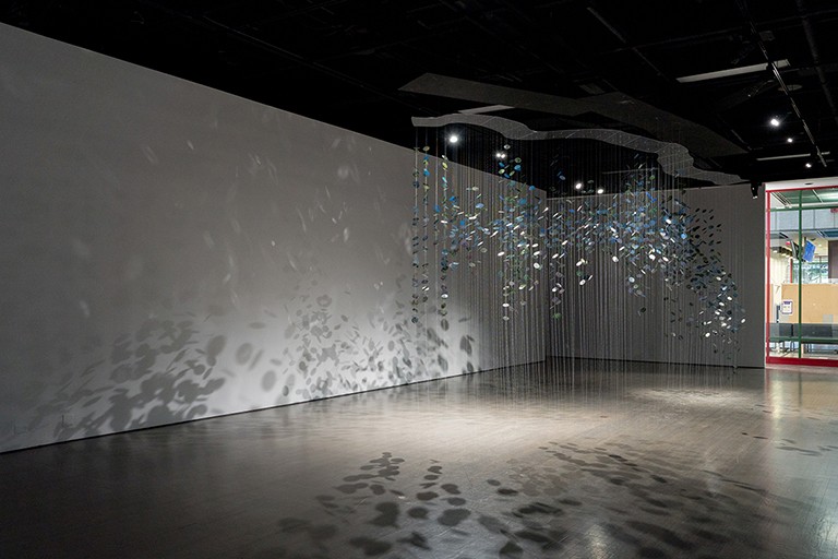 Coloured disks of glass hung from the ceiling in a gallery exhibit