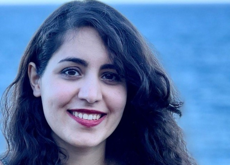 A woman with long dark hair smiling