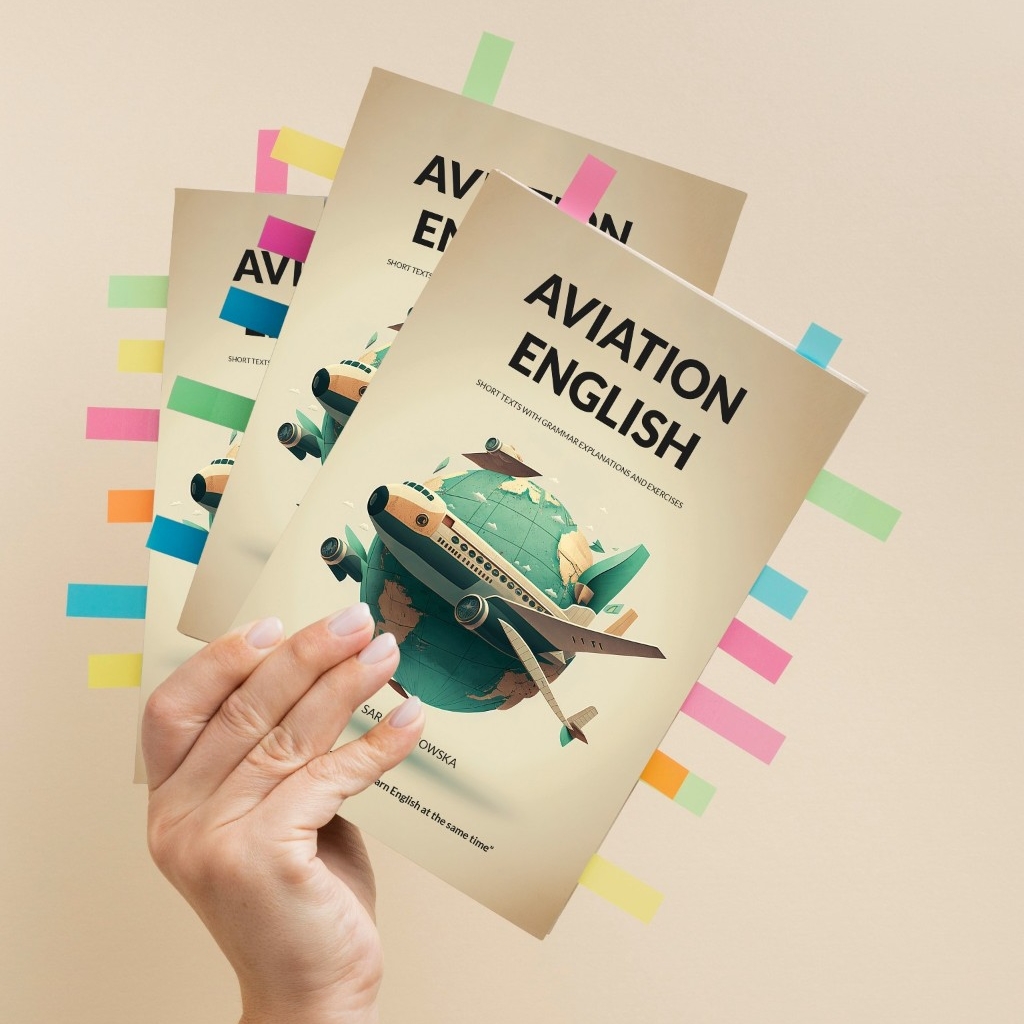 Une main tient une copie du livre, 'Avation English', avec de nombreuses notes autocollantes colorées sortant des pages. La couverture du livre est une image d'un avion avec un globe en arrière-plan.