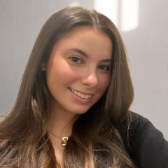 Un portrait d'une jeune femme souriante, aux cheveux bruns longs